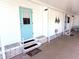 Inviting entrance features a charming turquoise door and comfortable covered seating area at 175 Palm Harbor Dr, North Port, FL 34287
