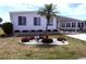Charming home with well-maintained landscaping, featuring a lovely palm tree and manicured bushes at 175 Palm Harbor Dr, North Port, FL 34287