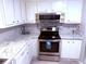 Charming kitchen features white cabinets, marbled countertops, and stainless steel appliances, offering modern convenience and style at 175 Palm Harbor Dr, North Port, FL 34287