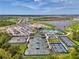 Panoramic aerial view of the community featuring tennis courts, a lake, a golf course, and the clubhouse with a pool at 17515 Jadestone Ct, Venice, FL 34293