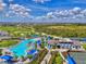 Expansive aerial view of the community's recreational area featuring a pool, clubhouse, golf course, and tennis courts at 17515 Jadestone Ct, Venice, FL 34293