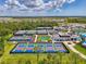 Wide aerial perspective showcasing the community's various amenities, including pickleball and tennis courts, and a clubhouse at 17515 Jadestone Ct, Venice, FL 34293