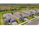 Community aerial view showing homes and lush green space along with a pond in the background at 17515 Jadestone Ct, Venice, FL 34293
