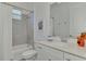 Bright bathroom features a shower over bath, light grey tile, and a white vanity at 17515 Jadestone Ct, Venice, FL 34293