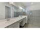 Bathroom with a double sink vanity, large mirror and walk-in shower at 17515 Jadestone Ct, Venice, FL 34293
