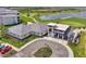 Beautiful aerial view featuring clubhouse with golf cart parking in front of golf course and pond at 17515 Jadestone Ct, Venice, FL 34293