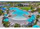 Stunning resort-style community pool with ample seating, blue umbrellas, lush landscaping, and a clubhouse for relaxing outdoors at 17515 Jadestone Ct, Venice, FL 34293