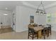 Bright dining room features a wooden table, modern lighting, and access to the front entrance at 17515 Jadestone Ct, Venice, FL 34293