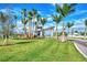 A beautifully landscaped entrance to a community with palm trees and a modern gatehouse, all under a bright blue sky at 17515 Jadestone Ct, Venice, FL 34293