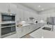 Bright kitchen with stainless steel appliances, modern cabinetry, and a view into the entry at 17515 Jadestone Ct, Venice, FL 34293