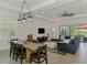 Spacious living room and dining area featuring wood-look floors, modern lighting, and backyard access at 17515 Jadestone Ct, Venice, FL 34293