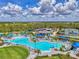 A stunning aerial view features a community pool, tennis courts, and lush landscaping creating a vibrant recreational space at 17515 Jadestone Ct, Venice, FL 34293