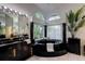 A luxurious primary bathroom showcases a round soaking tub next to a set of windows overlooking the outdoor area at 181 S Auburn Rd, Venice, FL 34292