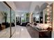 This spacious bathroom features a soaking tub, natural light, and a vanity with Hollywood-style lighting at 181 S Auburn Rd, Venice, FL 34292