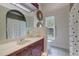 Bathroom featuring arched window, vanity, decorative wall mirrors, and polka dot shower curtain at 181 S Auburn Rd, Venice, FL 34292