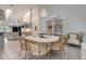 Dining area with wicker chairs, an elegant chandelier, and an open view of the kitchen at 181 S Auburn Rd, Venice, FL 34292
