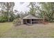 Cozy one-story home featuring a screened-in porch and landscaped yard, nestled amidst mature trees at 181 S Auburn Rd, Venice, FL 34292