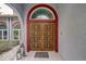 Detailed view of solid wood double doors with unique design and decorative lanterns at 181 S Auburn Rd, Venice, FL 34292