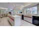 Bright kitchen with an island, ample counter space, and view into the dining area at 181 S Auburn Rd, Venice, FL 34292