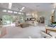 Bright living room with skylights, tile flooring, and open layout to the kitchen and dining area at 181 S Auburn Rd, Venice, FL 34292