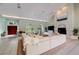 Bright living room with high ceilings, arched windows, fireplace, and a large, comfortable white leather sectional sofa at 181 S Auburn Rd, Venice, FL 34292