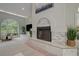 Living room featuring a fireplace with stone surround, built-in shelving, and large windows at 181 S Auburn Rd, Venice, FL 34292