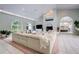 Spacious living room with fireplace, white sectional sofa, and large windows overlooking the lush landscape at 181 S Auburn Rd, Venice, FL 34292