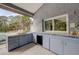 Covered outdoor kitchen with sink and built in fridge at 181 S Auburn Rd, Venice, FL 34292