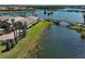 Waterfront home with manicured lawn, bridge access to community, and serene lake views at 19240 Isadora St, Venice, FL 34293