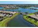 Beautiful aerial view of a Primary planned community with shimmering lakes, lush landscaping, and tiled roofs at 19240 Isadora St, Venice, FL 34293