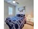 Bedroom featuring large bed with blue and white geometric patterns, as well as a bright window at 19240 Isadora St, Venice, FL 34293