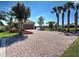 Spacious paver driveway leading to a well-kept home with beautiful landscaping and a lake view at 19240 Isadora St, Venice, FL 34293