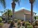 Well-maintained home with a two-car garage, lush landscaping, and palm trees at 19240 Isadora St, Venice, FL 34293