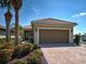 Attractive home with a two-car garage, brick driveway, and vibrant flower beds at 19240 Isadora St, Venice, FL 34293