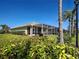 Well-manicured lawn with a screened-in patio and lush green landscaping at 19240 Isadora St, Venice, FL 34293