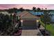 Lovely home with a tile roof, two-car garage, and beautifully landscaped yard, set against a scenic sunset at 19240 Isadora St, Venice, FL 34293