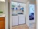 Laundry closet with washer, dryer, and shelving; doorway view to the main bedroom at 19240 Isadora St, Venice, FL 34293
