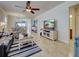 Open-concept living room with tile floors, coastal decor, and a modern TV at 19240 Isadora St, Venice, FL 34293
