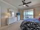 Bright main bedroom featuring a ceiling fan and sliding glass doors to a screened-in lanai with water view at 19240 Isadora St, Venice, FL 34293