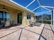 Screened patio with brick flooring and modern seating arrangements and fan at 19240 Isadora St, Venice, FL 34293