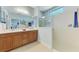 Bathroom with double vanity, walk-in shower, and light tile flooring at 20246 Pezzana Dr, Venice, FL 34292
