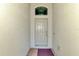 A simple, inviting front door entrance of the home with neutral paint and a transom window at 20246 Pezzana Dr, Venice, FL 34292