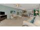 Bright living room with white sofas, table, and open layout leading to the kitchen area at 20246 Pezzana Dr, Venice, FL 34292