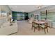 Open-concept living room boasts white sofas, a decorative cabinet, and sliding glass doors with lake views at 20246 Pezzana Dr, Venice, FL 34292