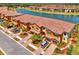 Aerial view of townhomes with tile roofs, garages, and a scenic lake view at 20390 Lagente Cir, Venice, FL 34293