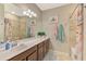 Bathroom featuring single sink, granite counters, ceramic tile, tub and views to an adjacent bedroom at 20390 Lagente Cir, Venice, FL 34293