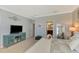 Well-lit bedroom features light grey walls, carpet floors, entertainment center and an adjacent bathroom at 20390 Lagente Cir, Venice, FL 34293