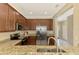 Modern kitchen features stainless steel appliances, granite countertops, and wood cabinets at 20390 Lagente Cir, Venice, FL 34293