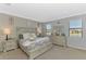 Main bedroom with windows overlooking a lake, carpet floors, and neutral walls at 20390 Lagente Cir, Venice, FL 34293