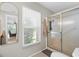 Bathroom with glass enclosed shower, large window and framed mirror at 205 Cavallini Dr, Nokomis, FL 34275